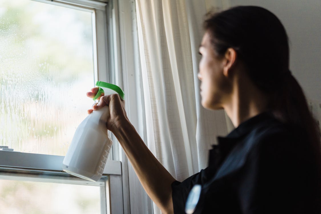femme en train de nettoyer sa fenêtre